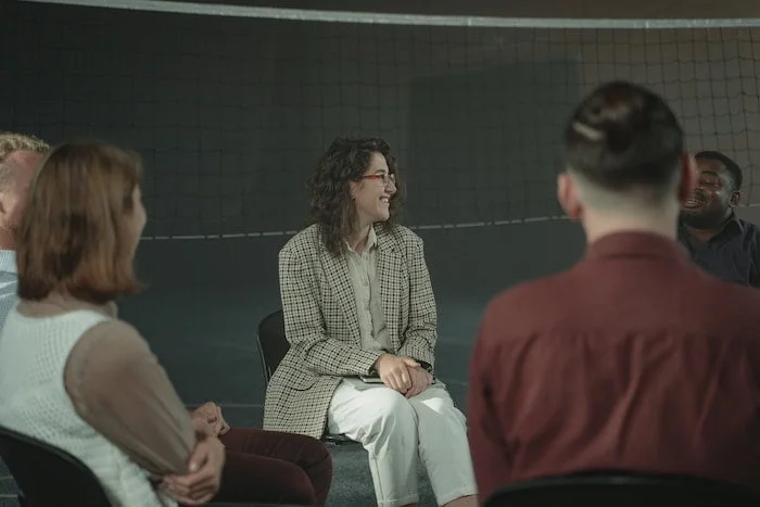 People sat together and smiling during an Alcoholics Anonymous meeting