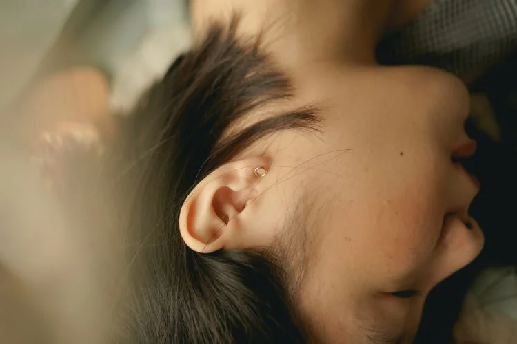 A side view of a woman's ear and profile