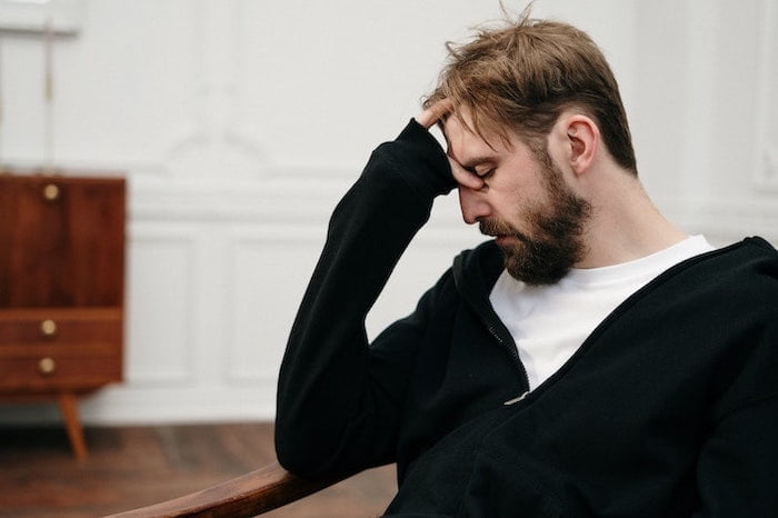 Man holding his head suffering from insomnia and addiction