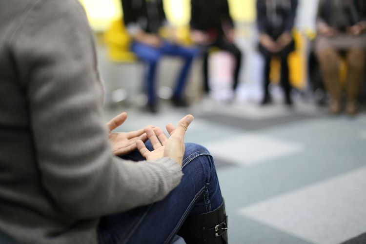 People at a group therapy session for addiction listening to a speaker