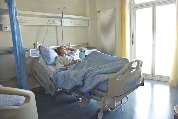 Patient lying in a hospital bed suffering from the effects of alcohol on the body