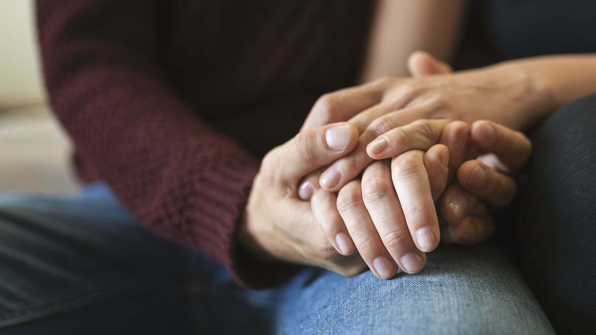 Two people holding hands and talking about sex and love addiction