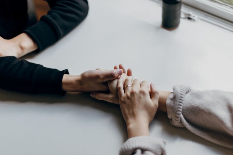 Two people holding hands discussing alcoholism in the LGBTQ community